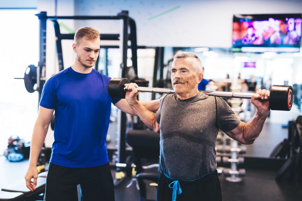 eğitmen eşliğinde spor yapan yaşlı adam