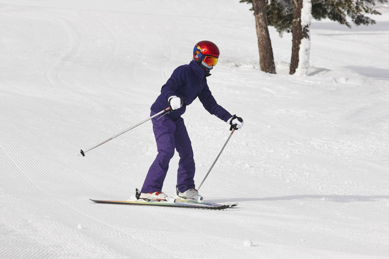karlı bir zirvede kayak yapan genç adam