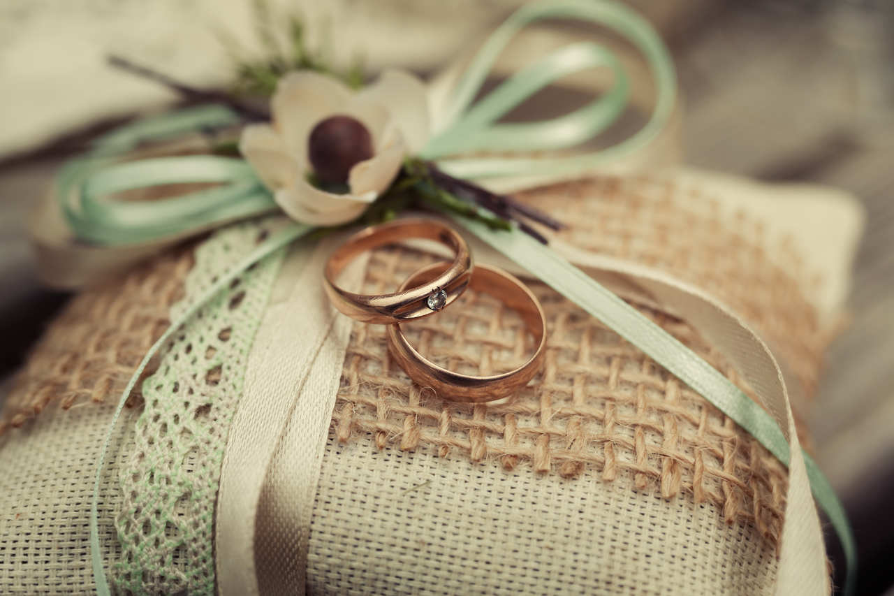 dantel ile süslenmiş yastık üzerinde bir çift nişan yüzüğü