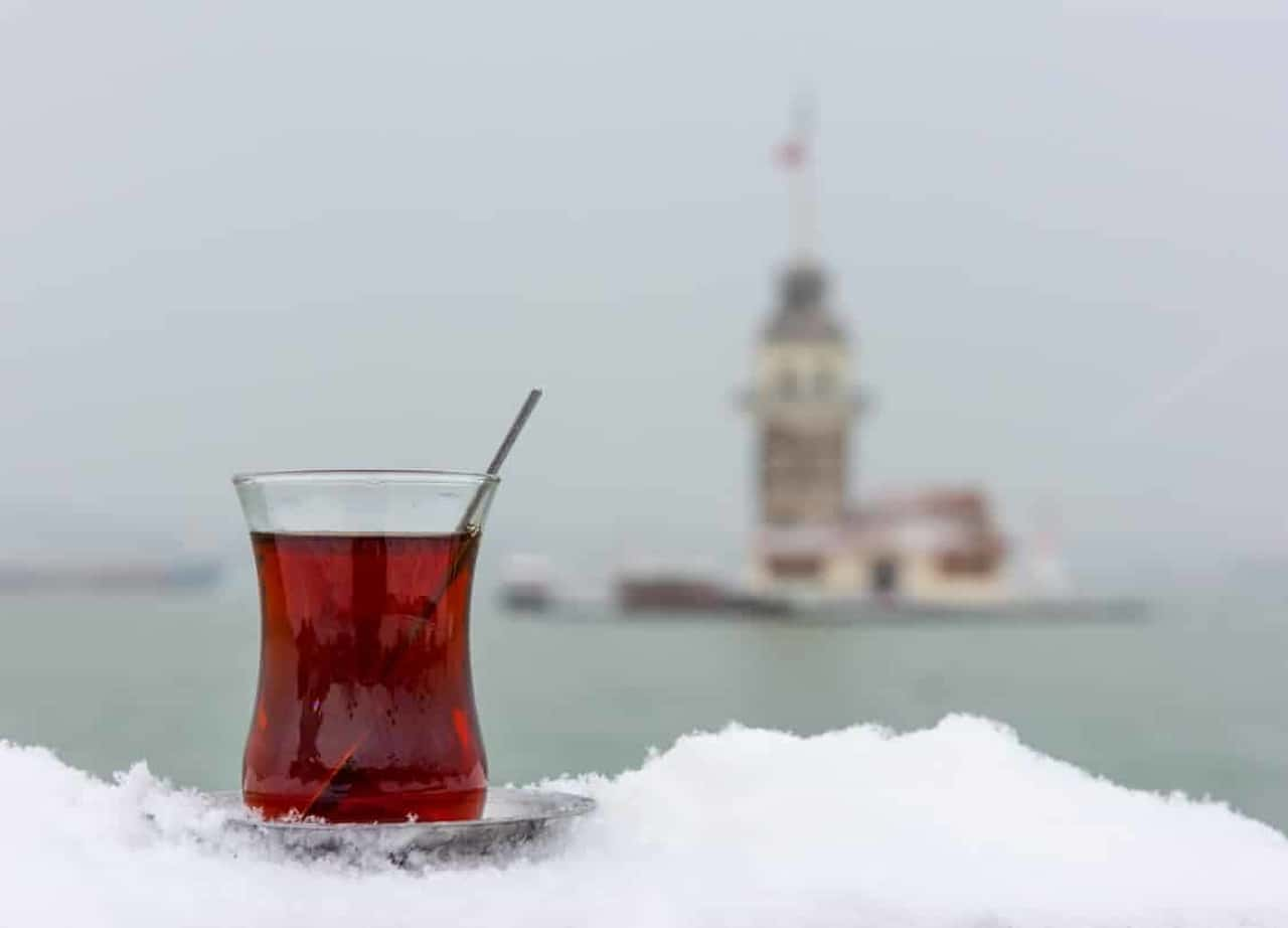 Ön planda bir bardak çay ve arka planda Kız Kulesi'nin göründüğü bir manzara