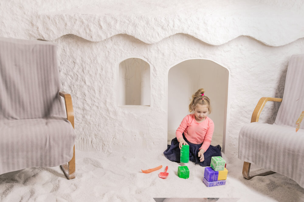 little girl playing toys in salt cave 