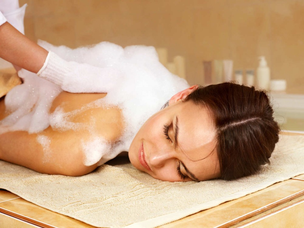 a woman getting massage and clean in turkish bath