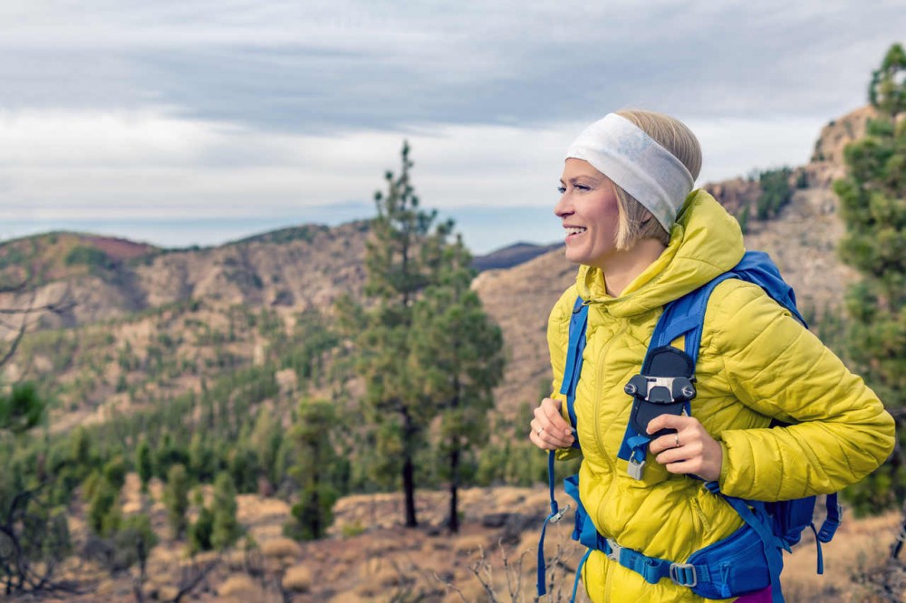 Hiking woman with backpack looking at inspirational mountains