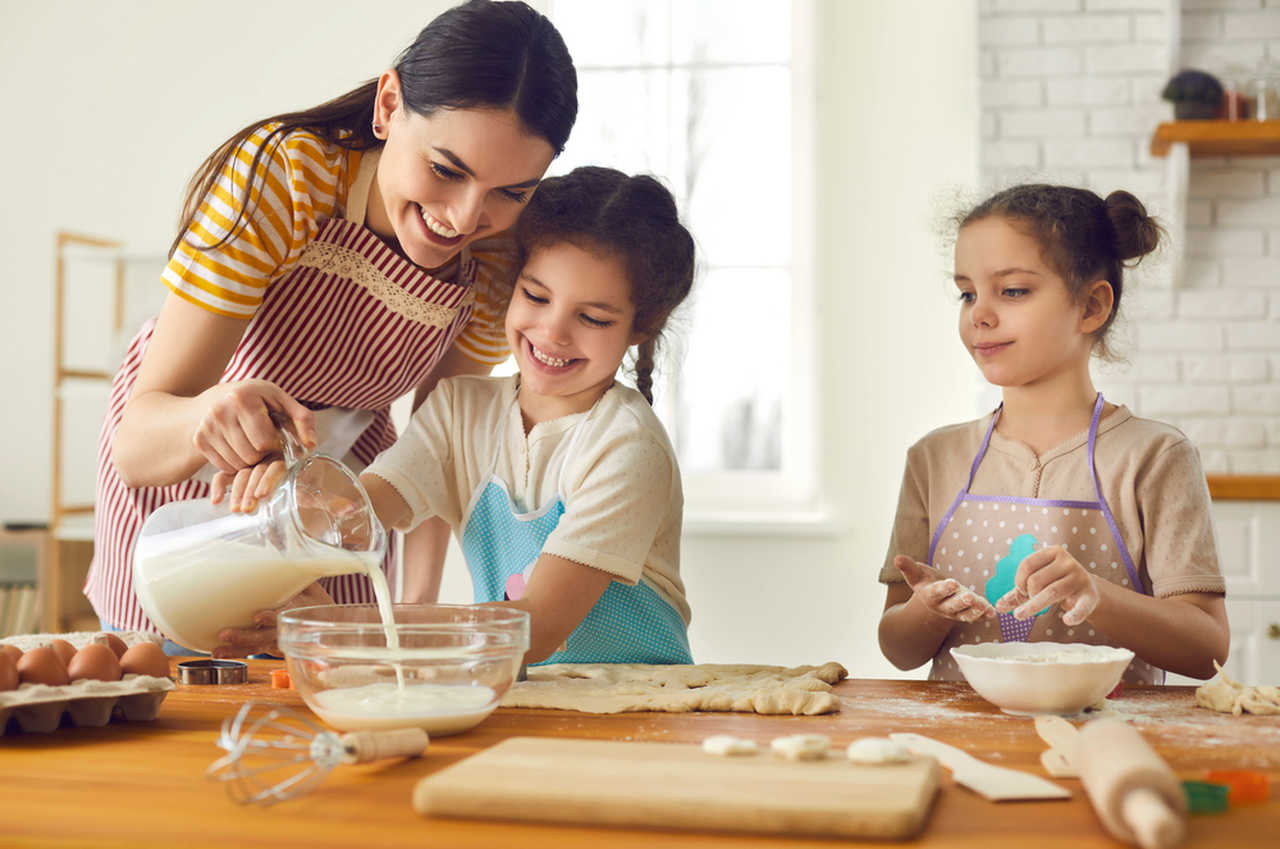 anne ve kızları birlikte kurabiye yapıyor