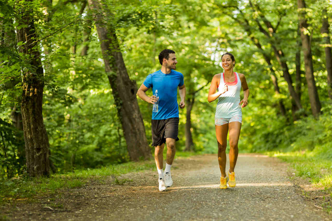 ormanlık alanda koşarak spor yapan genç çift