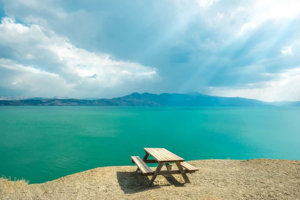 Hazar gölü kenarında duran ahşap piknik masası ve göl manzarası