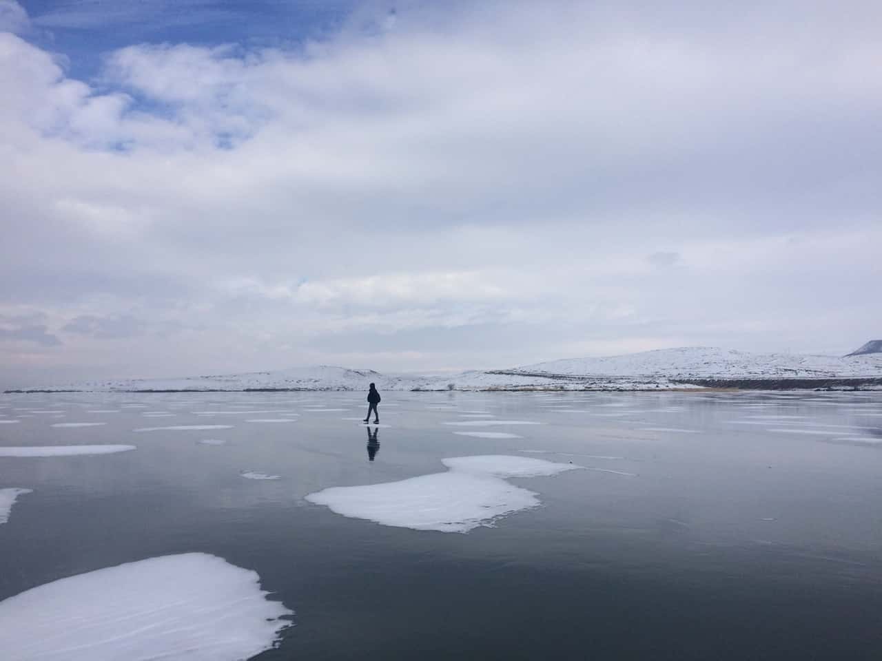 soğuktan donmuş Çıldır Gölü üzerinde yürüyen adam