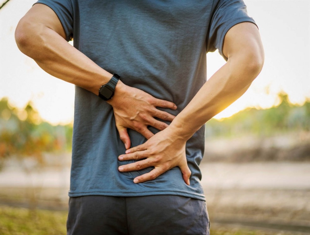 man holding his back 
