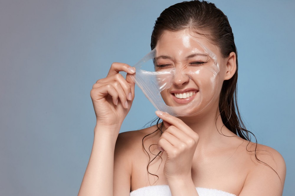 woman taking peeling mask of her face