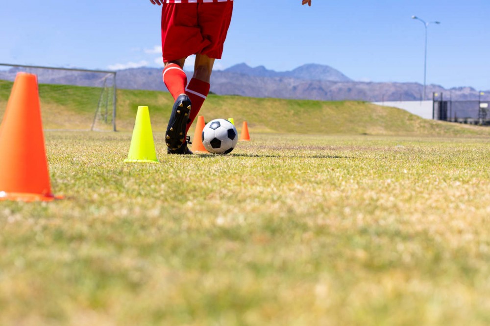 A soccer player training with cones
