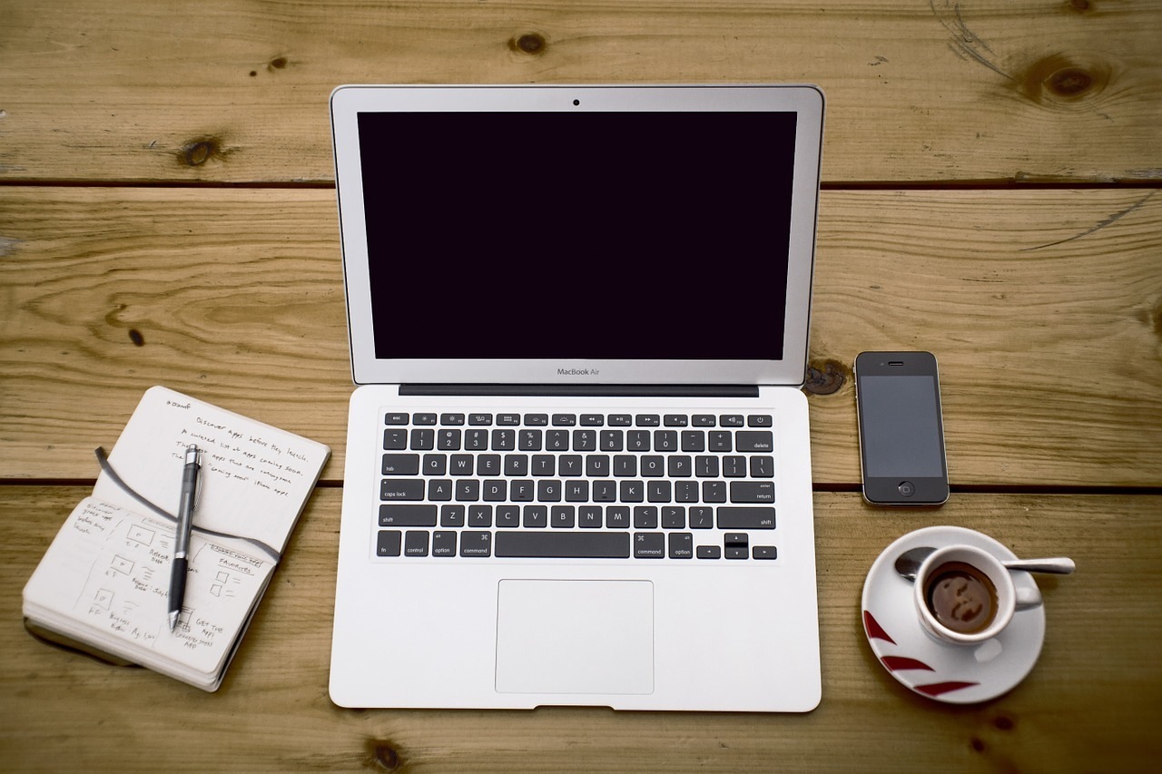 bilgisayar, kahve, bilgisayar ve not defterinden oluşan blogger masası